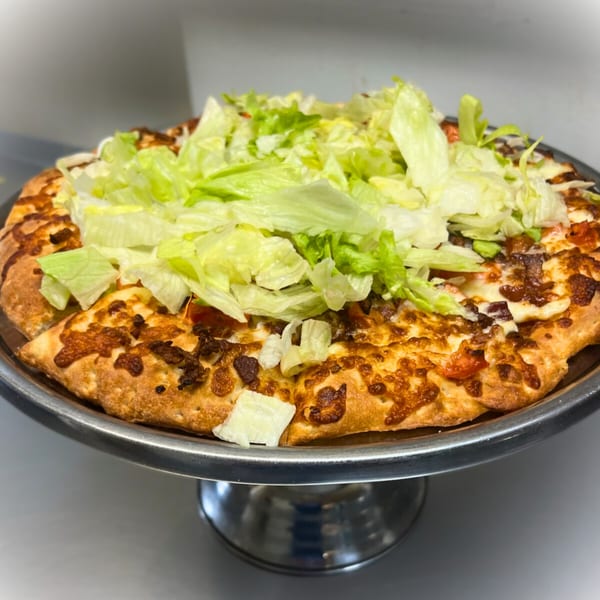 Cicero's Pizza with melted cheese, crispy crust, and a generous topping of fresh shredded lettuce.
