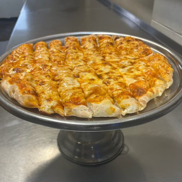 Cicero's Pizza cheese breadsticks, cut into strips, on a metal serving platter.